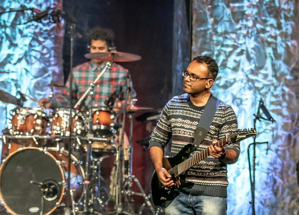 Moncy playing a 7-string guitar at church in 2017